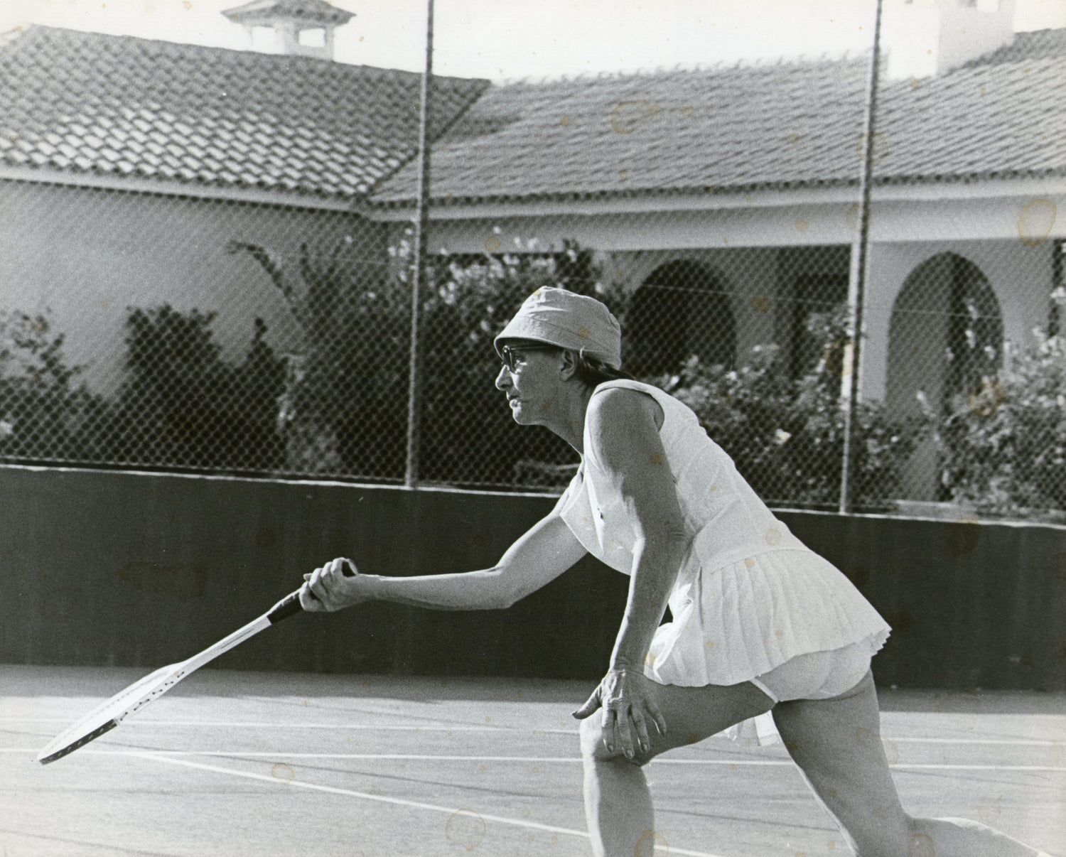 Kajsa spelar tennis. Bild i gråskala.