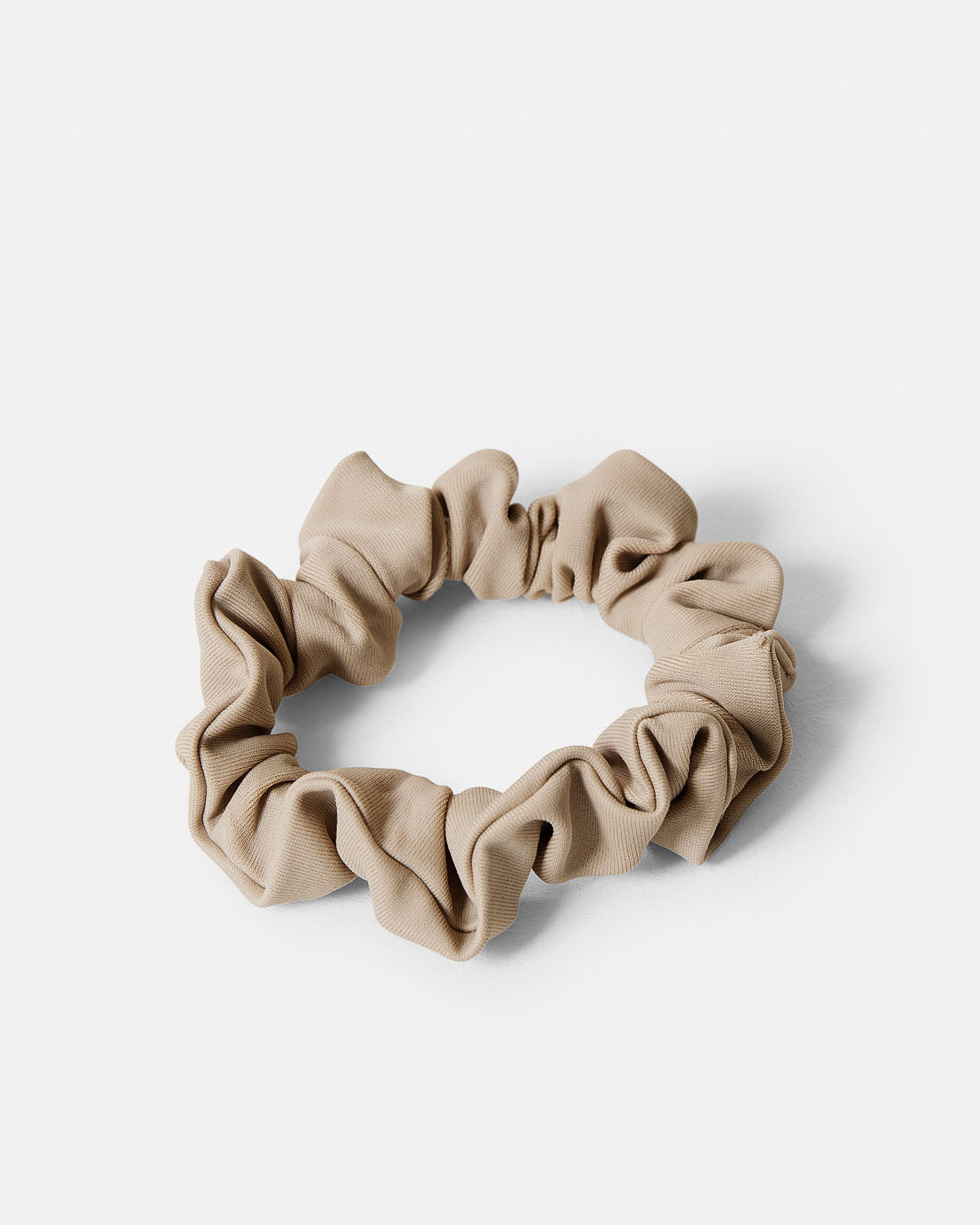 Beige scrunchie i en smalare modell. Sydda av överblivet tyg från tillverkningen av våra kjolar. Återvunnet tyg.