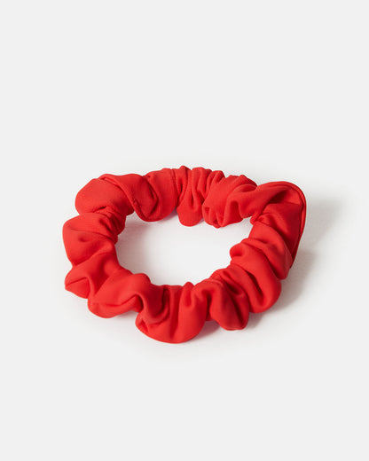Orange  scrunchie i en smalare modell. Sydda av överblivet tyg från tillverkningen av våra kjolar. Återvunnet tyg.