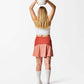 Sportkjol sedd bakifrån. Tvåfärgad. Korallröd överst och aprikos nederst. Klockad bak.