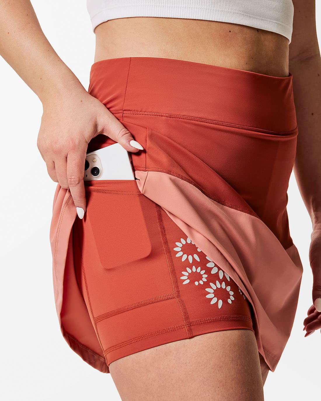 Sportkjol med stora fickor på innerbyxan. Tvåfärgad. Korallröd överst och aprikos nederst.