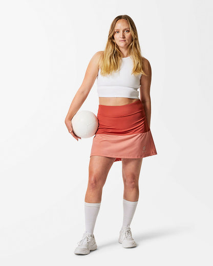 Lång Sportkjol för padel och tennis. Tvåfärgad. Korallröd överst och aprikos nederst.
