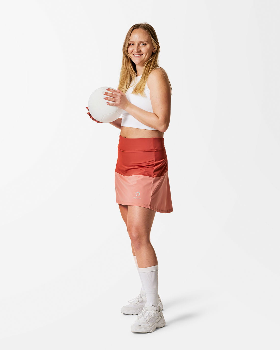 Lång Sportkjol sedd från sidan. Tvåfärgad. Korallröd överst och aprikos nederst.